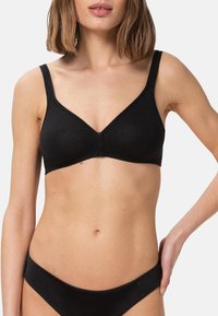 Svart trådlös bh med V-ringning, gjord av mjukt tyg. Har justerbara band och en stängning fram. Slät, utan synliga sömmar.