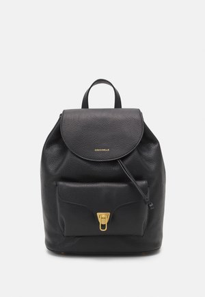 Zaino in pelle nera con patta arrotondata, tasca frontale, hardware dorato e finitura testurizzata. Include una maniglia superiore e spallacci regolabili.