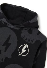 Sudadera con capucha en negro y gris que presenta un patrón de calaveras, un logo de rayo en blanco y un tejido suave y texturizado.