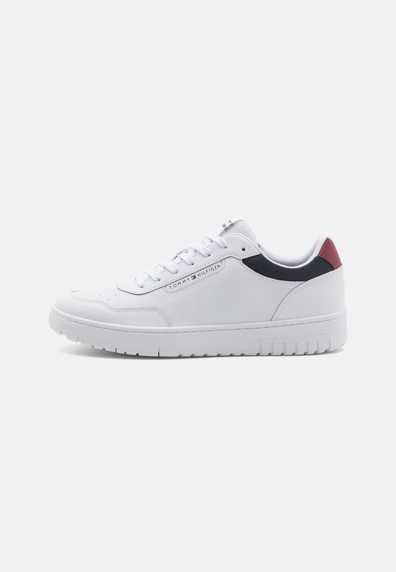 Baskets en cuir blanc avec une pointe ronde, dotées d'accents bleu marine et bordeaux sur les côtés, de lacets plats et d'une semelle en caoutchouc texturé.