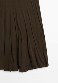 Tissu plissé marron avec des plis doux formant une forme évasée, présenté sur un fond blanc uni.