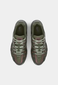 Nike sneakers with a mesh upper in olive green and burgundy, featuring gray accents, round laces, and a prominent logo on the tongue.