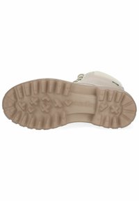 Botte de couleur claire avec une semelle en caoutchouc texturée, présentant de profonds crampons et un talon renforcé pour une adhérence et une durabilité accrues.