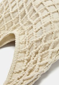 Gehaakte katoenen tas met een beige, gestructureerd oppervlak, voorzien van een ruitpatroon. De handvatten zijn ook gemaakt van gevlochten katoen.