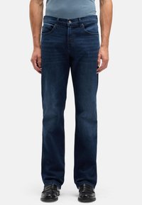Ciemnoniebieskie jeansy z prostą nogawką, wyposażone w przednie kieszenie, metalowy guzik w pasie oraz starannie wykończone na dole.