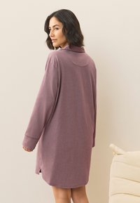 Abito a maniche lunghe, modello pullover, realizzato in morbido tessuto malva. Caratterizzato da un colletto pieghevole, spaccature laterali e una vestibilità comoda e rilassata.