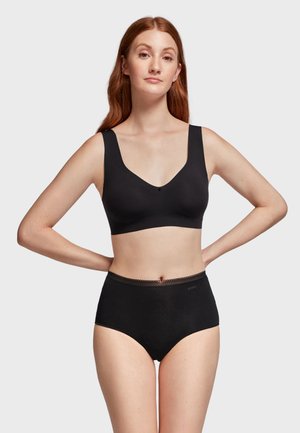 Soutien-gorge sans fil noir avec de larges bretelles et un décolleté en V profond, assorti à des culottes de bikini noires taille haute avec un détail en bordure festonnée.