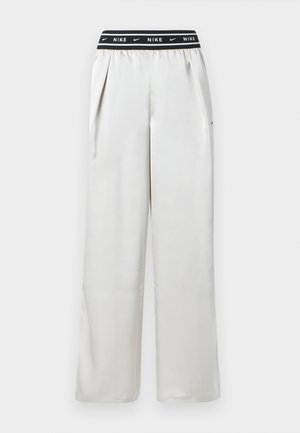 Mjukisbyxor i ljusgrått från Nike med svart elastisk midjeresår och varumärkeslogotyp. Plisserad modell med sidofickor. Slät textur.