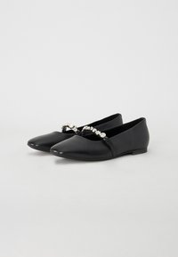 Ballerine in pelle nera con punta affusolata, caratterizzate da una fascia decorativa di pietre trasparenti sulla parte anteriore. Texture liscia e tacco basso.