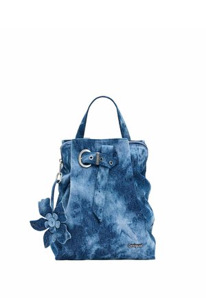 Niebieska torebka z denimu tie-dye z górnymi uchwytami, srebrnym paskiem z klamrą, zawieszką w kształcie kwiatu i logo Desigual w dolnym prawym rogu.