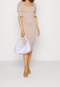 Robe midi à imprimé floral avec des manches bouffantes, marron clair, style ajusté. Sac à main lavande avec une texture douce. Sandales à glissière tressées beiges.