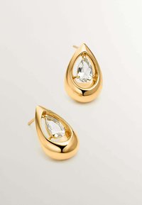 Pendientes en forma de lágrima de oro con un cristal transparente en forma de pera en el centro, acabado suave y cierre de tipo poste para un uso seguro.