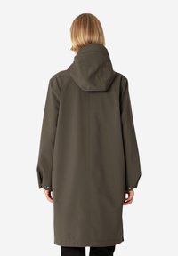 Impermeable verde oliva con capucha, mangas largas y cierres a presión en los puños. Material liso y resistente al agua, con un diseño de longitud media.
