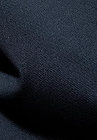 Dunkelblauer Stoff mit einer strukturierten Oberfläche, die kleine, erhabene Punkte gleichmäßig verteilt aufweist, flexibel und glatt im Griff.