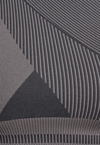 Texturerad tyg i mörkgrått med vågiga och randiga mönster, där variera bredder och nyanser skapar en modern geometrisk design.