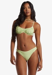 Groene geblokte bikini met geraffineerde details. De top heeft verstelbare bandjes en de onderkant heeft een lage taille. Zachte textuur overal.