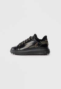 Svarte lær sneakers med pelsfôr, dekorert med gullnagler og et bølgemønster. Har svart gummisåle og detaljer i gull.