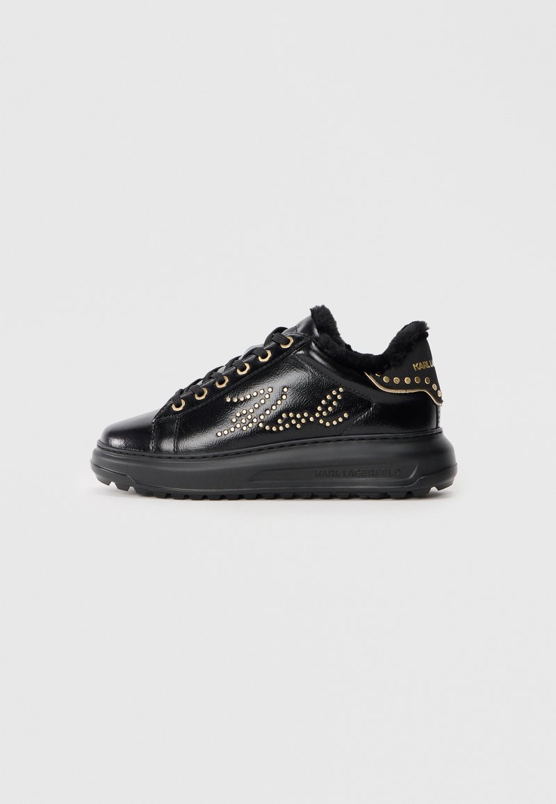 Svarte lær sneakers med pelsfôr, dekorert med gullnagler og et bølgemønster. Har svart gummisåle og detaljer i gull.