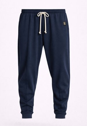 Pantaloni jogger blu navy con vita elastica e coulisse bianca, polsini a costine e piccolo patch logo quadrato sull'anca destra.