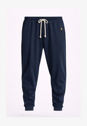 Pantaloni jogger blu navy con vita elastica e coulisse bianca, polsini a costine e piccolo patch logo quadrato sull'anca destra.