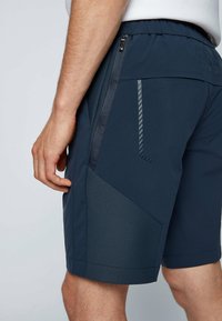 Námořnické šortky s texturovaným panelem, zipovými kapsami a elastickým pasem. Materiál vypadá lehce a prodyšně s hladkým povrchem.