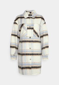 Chaqueta de forro polar en crema con un patrón de cuadros azules y negros, que cuenta con un cuello, un bolsillo frontal y cierre de botones a presión. Mangas largas.