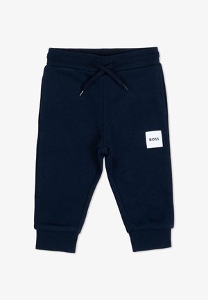 Granatowe spodnie dresowe dla małych dzieci z elastycznym pasem, sznurkiem do regulacji, ściągaczami przy kostkach oraz białą kwadratową łatką z napisem "BOSS" na górnej części nogawki.