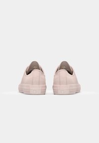 Baskets slip-on en toile rose clair avec un profil bas. Tige texturée, col rembourré et semelle en caoutchouc. Présente un logo en relief "CONVERSE ALL STAR".