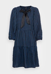 Robe à carreaux bleus avec de longues manches bouffantes, un nœud au niveau du décolleté et une jupe à volants. Fabriquée en tissu léger.