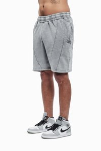 Grå bomullsshorts med elastisk midjebånd, med sidesømmer og knelangs snitt, paret med grå og svarte høye sneakers.