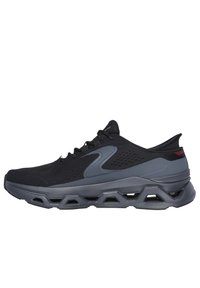 Chaussure de sport noire avec tige en mesh, accents gris, semelle en mousse moulée et design texturé. Lacets pour un ajustement sécurisé et une structure de soutien.