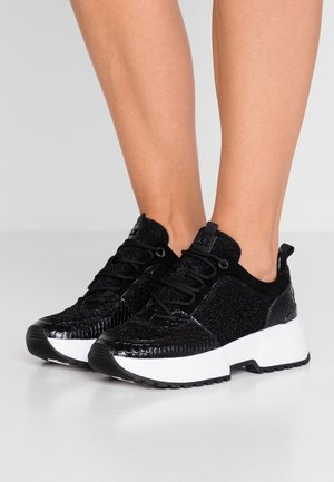 Sneaker neri con un motivo rettile testurizzato, dettagli brillanti e un alto tallone bianco spesso. Presentano un design con lacci e un collo imbottito.
