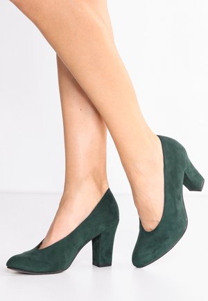 Grüne Wildleder-Pumps mit runder Zehenform und einem mittelhohen Blockabsatz. Das Design verfügt über einen tief geschnittenen Schuhblatt für ein schlankes Profil.
