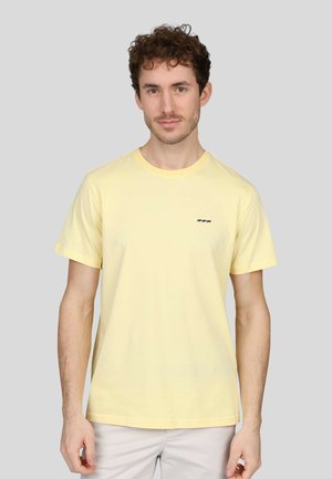 T-shirt en coton jaune avec un col rond, des manches courtes et un subtil détail graphique bleu sur la poitrine gauche.