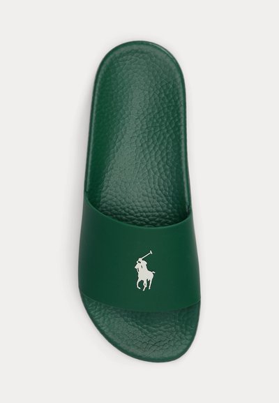 Zöld csúszásmentes papucs texturált talpbetéttel és fehér polo játékos logóval a pánton, felülről fehér háttéren.