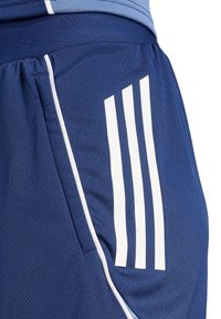 Marineblaue Sportshorts aus weichem, glattem Stoff; elastischer Bund; weißes Dreistreifen-Design an der Seite; Taschendetails.