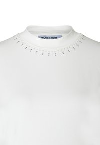 Weißes kurzärmliges Oberteil mit hochgeschlossenem Kragen und dekorativen, funkelnden Verzierungen um den Kragen. Hergestellt aus weichem Baumwollmaterial.