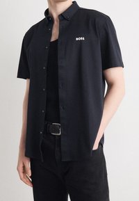 Korte mouwen, knoopsluiting shirt in donker marineblauw stof met een gladde textuur; beschikt over een merklogo op de borst en een klassieke kraag.