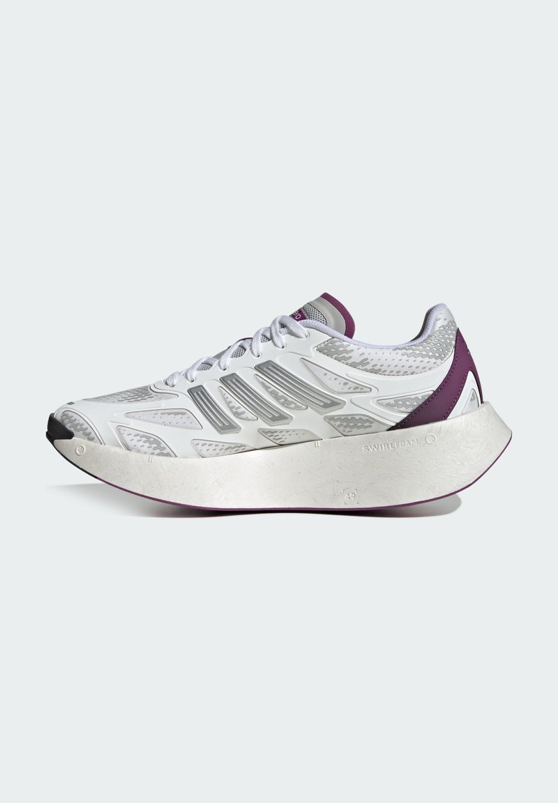 Chaussure de sport blanche avec des accents argentés, tige en maille texturée, semelle prononcée avec des accents violets et un détail de capuchon de orteil noir.