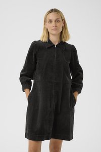Schwarzes Corduroykleid mit einem Reißverschluss vorne, spitzem Kragen und drei Viertelärmeln. Es hat seitliche Taschen und eine lässige Passform.
