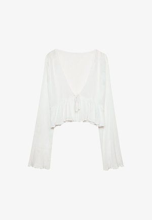 Blusa bianca a maniche lunghe, corta, con scollatura a V profonda, dettaglio con nodo sulla parte anteriore e orlo arricciato su uno sfondo semplice.