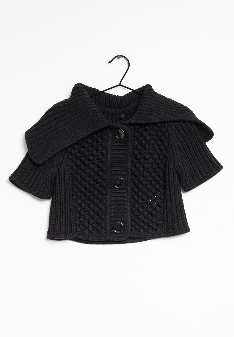Black knitted short-sleeve sweater with a large collar. Features textured pattern and four black buttons down the front. Hangs on a hook.