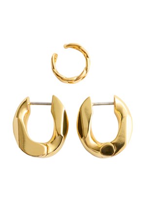 Kleine gedraaide gouden oormanchet boven een paar dikke gepolijste gouden oorringen met steker op een witte achtergrond.