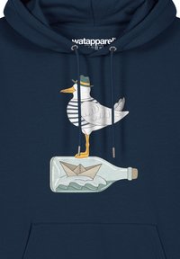Navy hoodie met een graphic van een meeuw in een groene hoed die op een fles staat met een papieren bootje, gedetailleerd met watergolven.