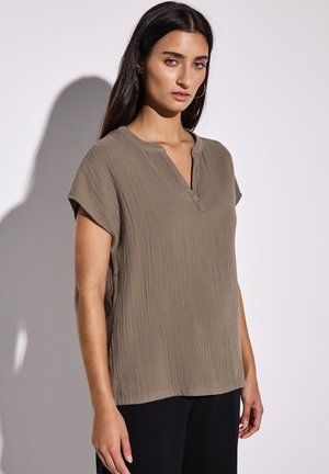 Top khaki a maniche corte con finitura testurizzata e colletto alla mandarino, dotato di una placca parziale e di una vestibilità rilassata.