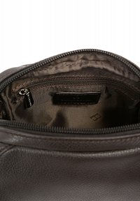 Interno di una borsa in pelle marrone con una fodera marrone chiaro. Presenta un comparto con cerniera e una tasca a scomparsa. Texture liscia, senza motivi.