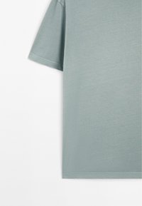Soft, light green short-sleeve T-shirt, made of cotton, with a relaxed fit and clean hem, featuring subtle texture and stitching detail.