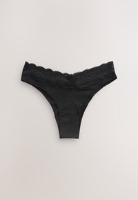 Mustad tangatüüpi aluspesu, millel on pitsiline ääris vöökohal, sile kangas ja keha järgnev lõige, pakkudes minimaalset katvust.