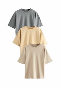 Trzy krótkie koszulki T-shirt ułożone jedna na drugiej: jedna szara, jedna jasnosłoneczna, a jedna beżowa. Miękka tkanina o luźnym kroju i okrągłych dekoltach.