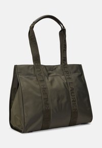 Oliivinvihreä nailonkangasta oleva olkalaukku, jossa on logolla painetut hihnat ja jämäkkä muotoilu, jossa on yläaukko helppoa käyttöä varten.